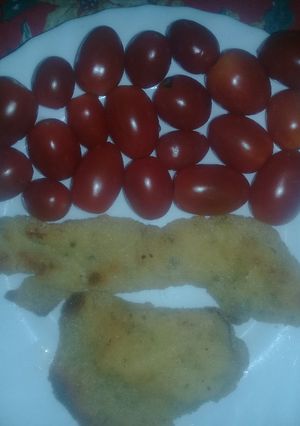 Una foto de Milanesa de pollo con tomatitos cherry