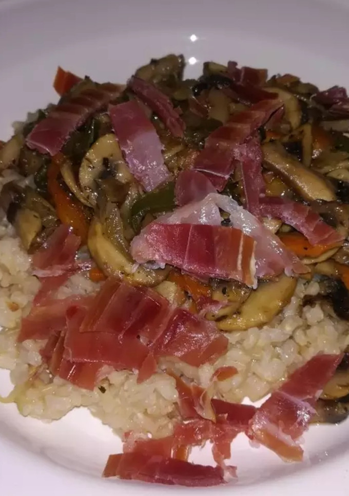 Una foto de Arroz integral, con champiñones y virutas de jamón