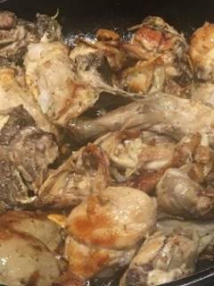Una foto de Conejo confitado al ajillo