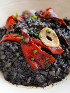 Una foto de Arroz negro meloso con sepia y pimientos del piquillo