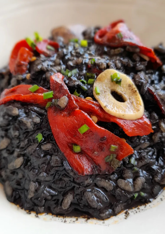Una foto de Arroz negro meloso con sepia y pimientos del piquillo