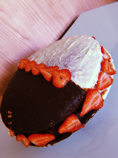 Una foto de Tarta rellena de fresas, nata y mermelada cubierta de dos chocolate