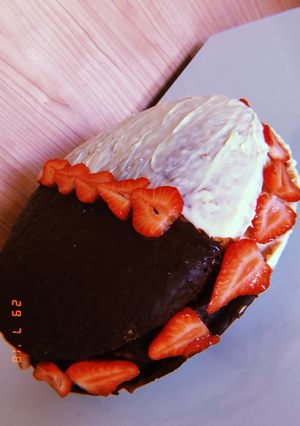 Una foto de Tarta rellena de fresas, nata y mermelada cubierta de dos chocolate