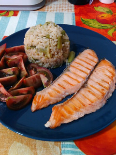 Una foto de Salmón a la plancha con guarnición de arroz integral con ajetes y tomate