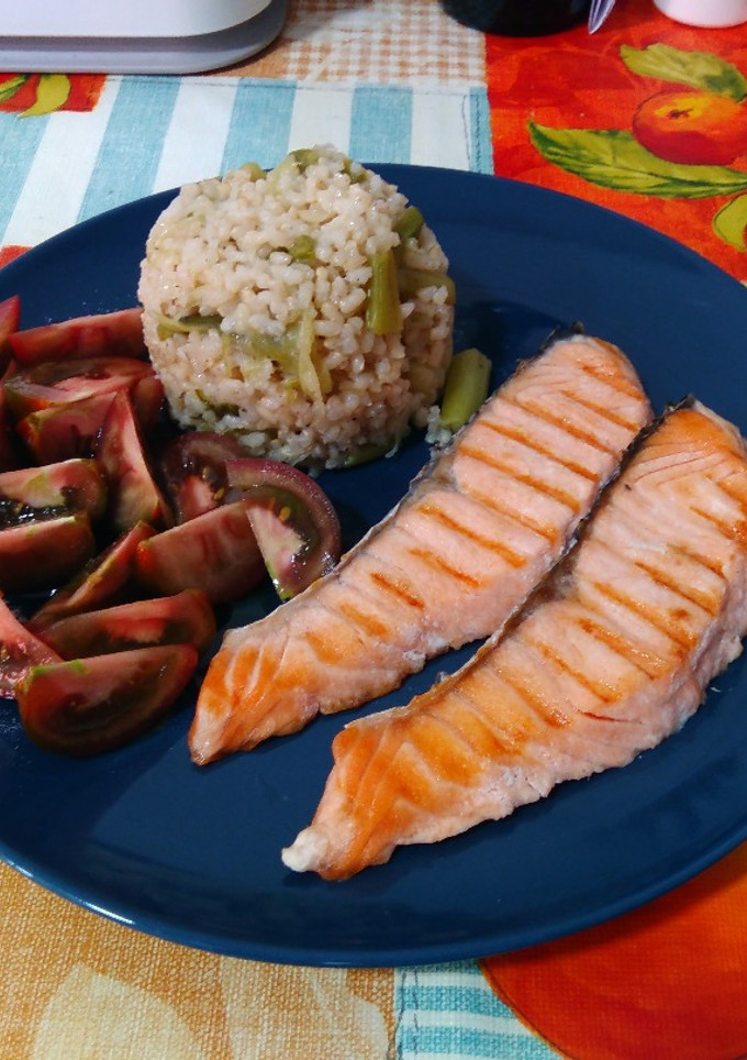 Una foto de Salmón a la plancha con guarnición de arroz integral con ajetes y tomate