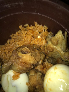 A picture of Title:yummy jollof rice garnished with fried turkey & eggs.