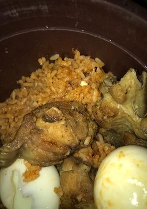 A picture of Title:yummy jollof rice garnished with fried turkey & eggs.