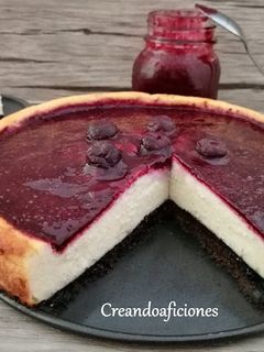 Una foto de Tarta de queso con salsa de arándanos casera