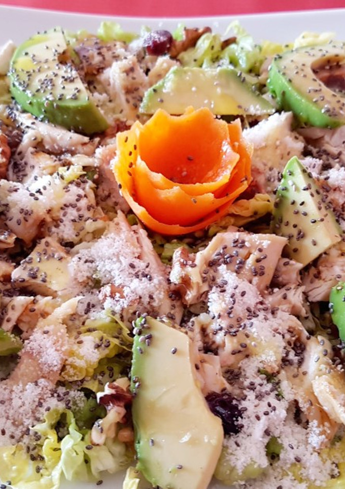 Una foto de Ensalada con pollo, aguacate, frutos secos, semillas y queso