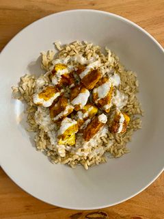 Una foto de 🍗 Pollo tandoori con arroz y salsa de yogur 🍚