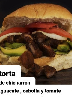 Una foto de Torta de chicharrón, aguacate, cebolla y tomate
