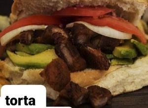 Una foto de Torta de chicharrón, aguacate, cebolla y tomate