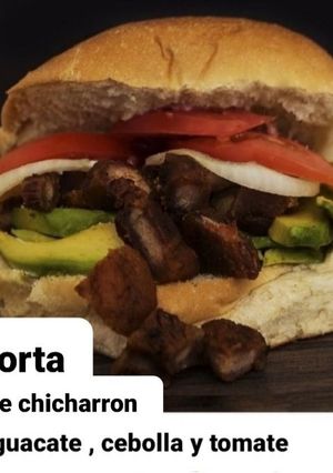 Una foto de Torta de chicharrón, aguacate, cebolla y tomate