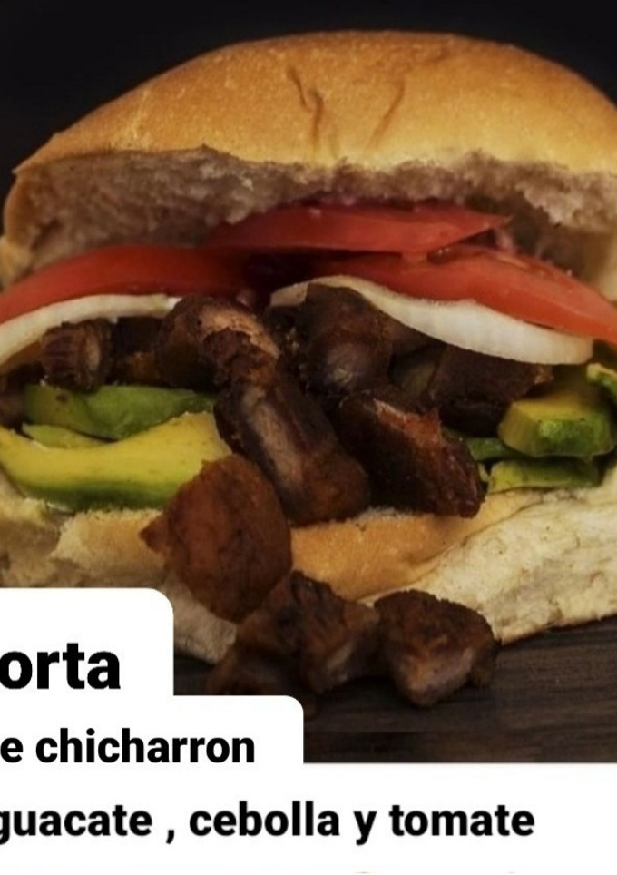 Una foto de Torta de chicharrón, aguacate, cebolla y tomate