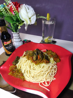 A picture of Spaghetti and beef sauce with lime water.