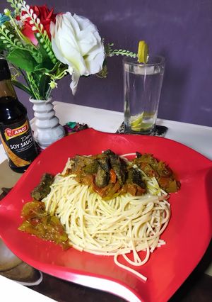 A picture of Spaghetti and beef sauce with lime water.