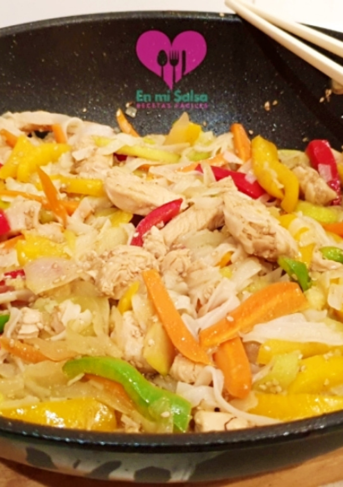 Una foto de WOK de verduras y pollo con fideos de arroz (noodles)