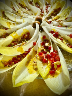 Una foto de Barquitas de endivia con granada y cremoso de frutos secos a la cúrcuma y curry