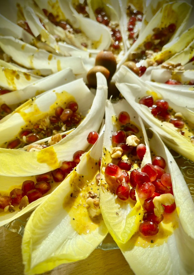 Una foto de Barquitas de endivia con granada y cremoso de frutos secos a la cúrcuma y curry