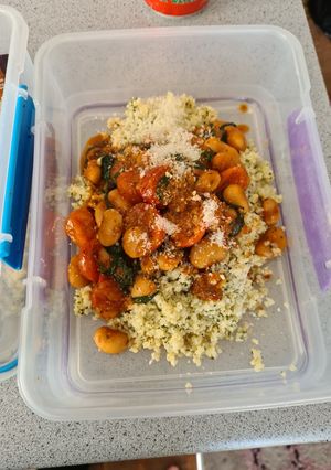 A picture of Butter bean and tomato stew with pesto bulgar and cheese.
