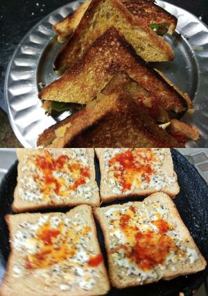 A picture of Chicken sandwich with cheesy garlic bread.