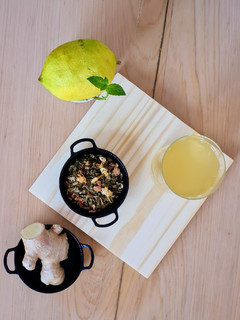 Una foto de Té verde helado con flores, jengibre, limón y menta