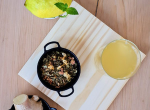 Una foto de Té verde helado con flores, jengibre, limón y menta