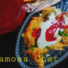 A picture of Samosa Chat with Laal chutni.