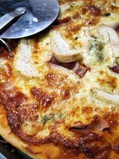 Una foto de Pizza trufada de bacon, pera y gorgonzola