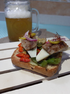 Una foto de Tosta de pan integral sardina ahumada queso ibérico y pimientos