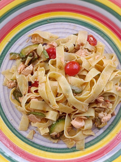 Una foto de Pasta con salmón zucchini y cherry