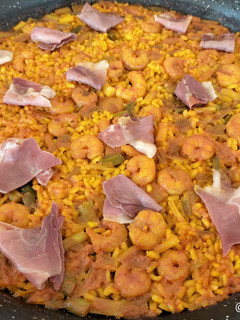 Una foto de Arroz con ajos tiernos, gambas y jamón