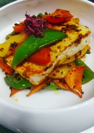 A picture of Spicy paneer steak with charred bell peppers.