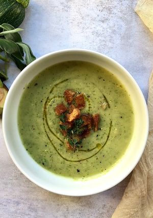 A picture of Courgette and avocado soup with croutons.