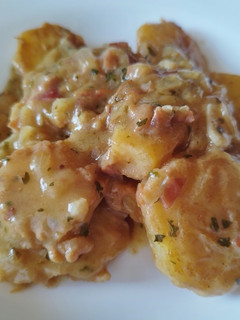 Una foto de Patatas a la importancia con jamón serrano