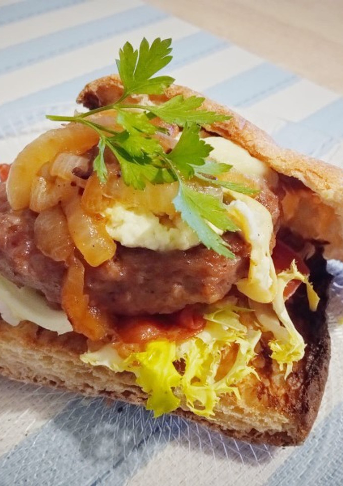 Una foto de Burger (pan de cristal) con crujiente de jamón, escarola y romesco