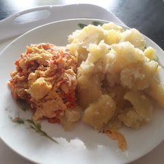 A picture of Boiled freh potatoes with fried eggs.