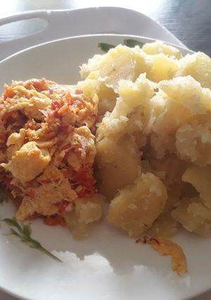 A picture of Boiled freh potatoes with fried eggs.