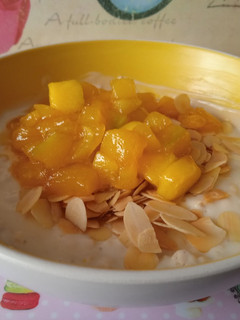 Una foto de Yogurt con avena, almendra y mango caramelizado