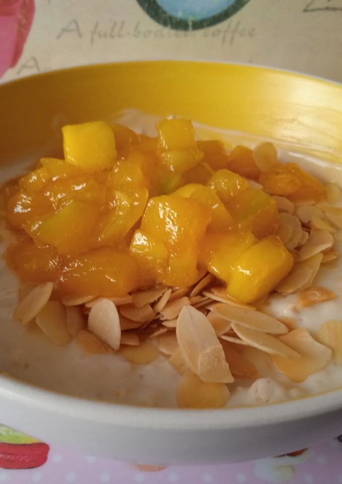Una foto de Yogurt con avena, almendra y mango caramelizado