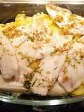 Merluza con cama de patatas al horno