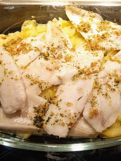 Una foto de Merluza con cama de patatas al horno