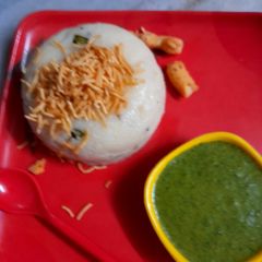 A picture of Upma with a combination of green chutney and aloo bhujiya.