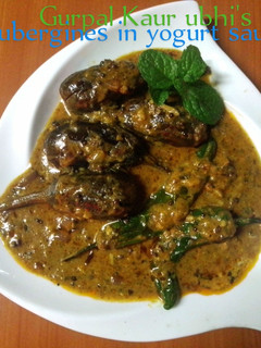 A picture of Aubergines in yogurt sauce🧅🍅🌿.