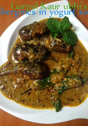 A picture of Aubergines in yogurt sauce🧅🍅🌿.