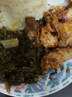 A picture of Ugali served with chicken and spinach.