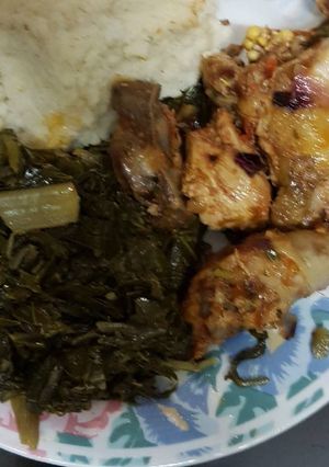 A picture of Ugali served with chicken and spinach.