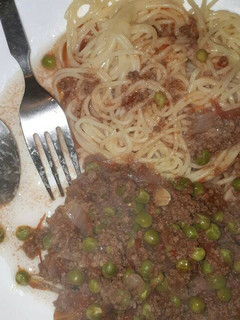 A picture of Spaghetti served with minced meat and peas.