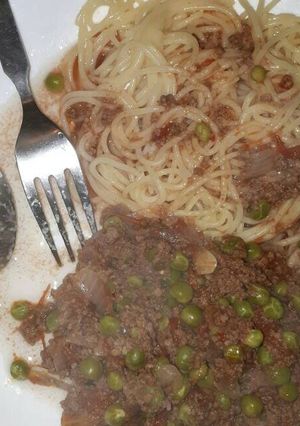 A picture of Spaghetti served with minced meat and peas.
