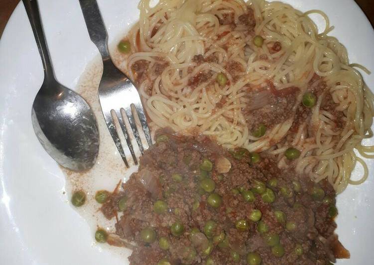 Spaghetti served with minced meat and peas